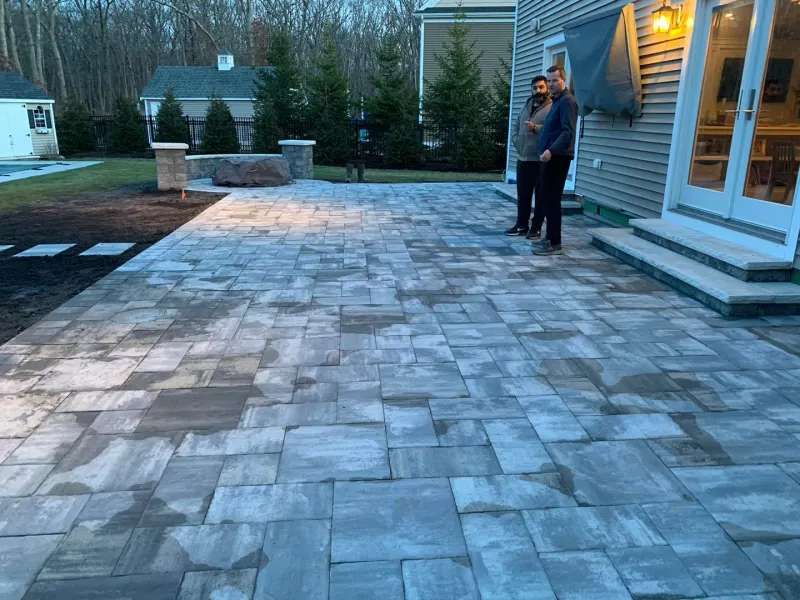 Paver patio behind a home at dusk