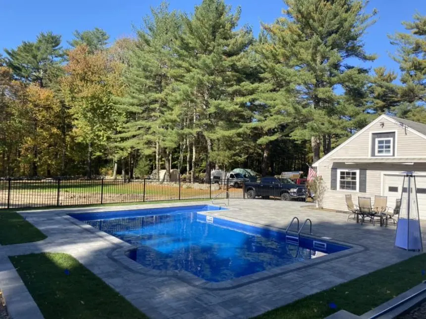 Finished inground pool with paver surround and fenced yard